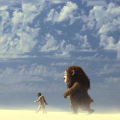 Still from the movie Where the Wild Things Are showing Max and a monster Carol walking across a sand desert under a bright blue sky.